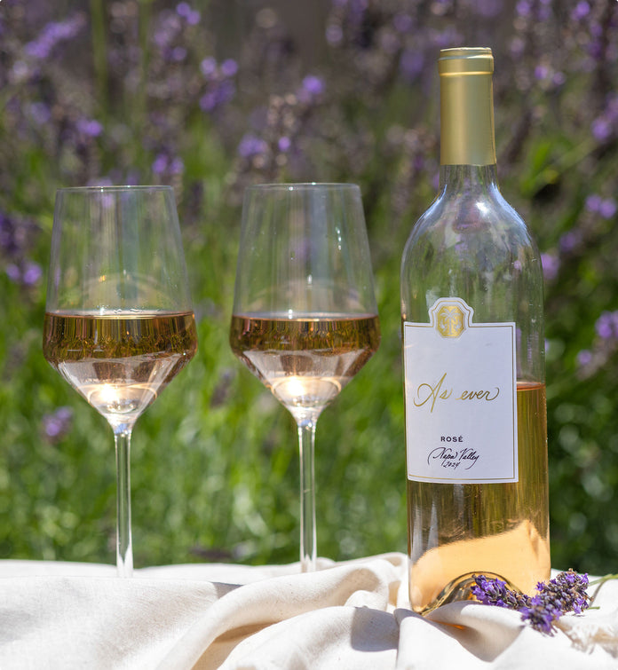 Two glasses and a bottle of As ever Rosé wine on a blanket with lavender in the background