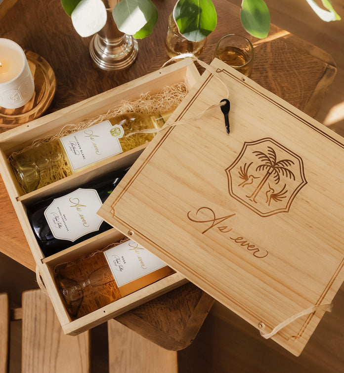 As ever wooden crate with engraved As ever logo and wine bottles inside on a wooden table